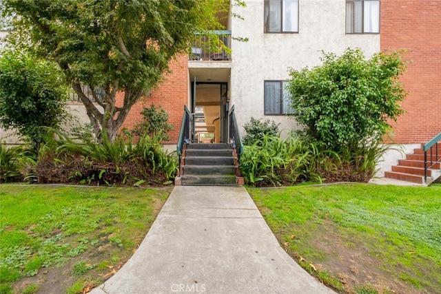 doorway to property with a lawn