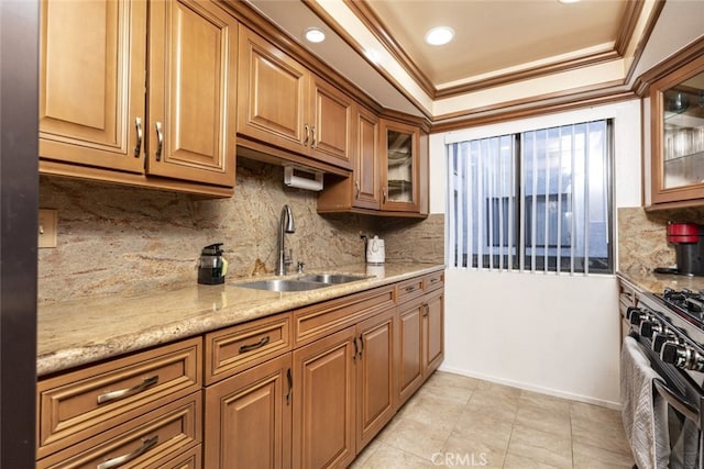 kitchen featuring crown molding, sink, gas range oven, tasteful backsplash, and light stone counters