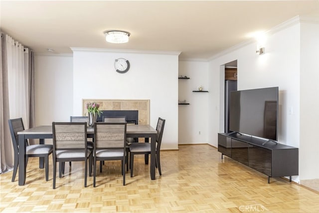 dining space with crown molding and light parquet flooring