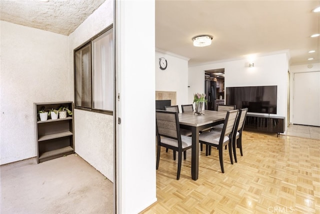 dining space with a fireplace, light parquet floors, and ornamental molding