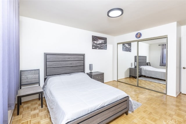 bedroom with light parquet flooring and a closet