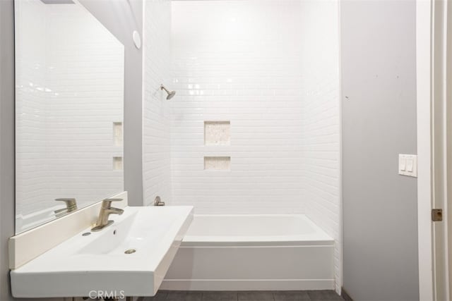 bathroom featuring tiled shower / bath combo, sink, and tile patterned flooring