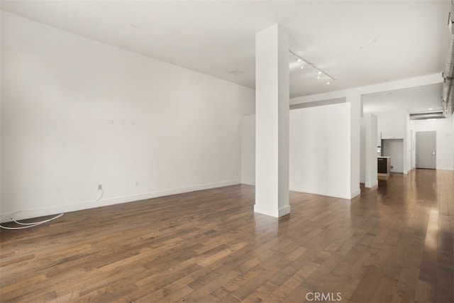 spare room featuring dark wood-type flooring and rail lighting