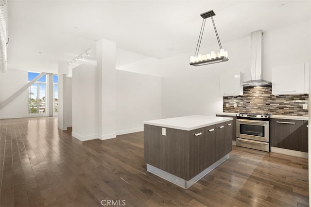 kitchen with a kitchen island, wall chimney range hood, dark hardwood / wood-style floors, stainless steel range, and white cabinetry