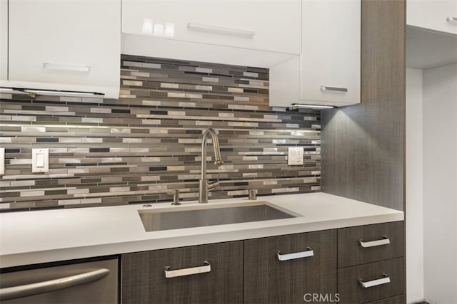 kitchen with decorative backsplash, dishwasher, sink, dark brown cabinetry, and white cabinets