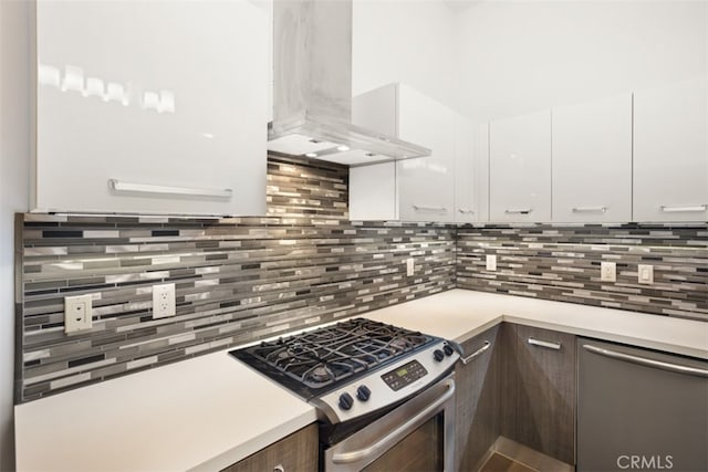 kitchen with wall chimney exhaust hood, backsplash, dark brown cabinetry, white cabinetry, and appliances with stainless steel finishes