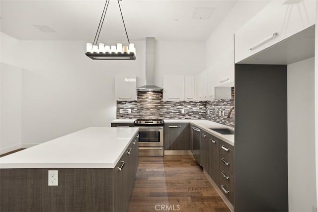 kitchen with white cabinetry, pendant lighting, wall chimney exhaust hood, dark brown cabinetry, and stainless steel appliances