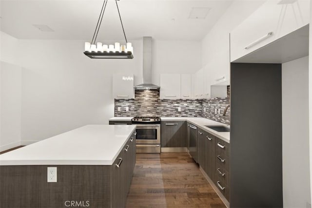 433 Pine Ave Unit 304, Long Beach, CA 90802 - kitchen featuring appliances with stainless steel finishes, wall chimney exhaust hood, a sink, dark wood finished floors, and white cabinets