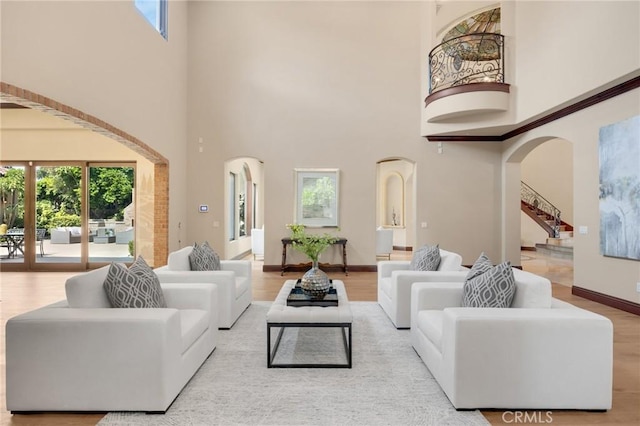 living room featuring light wood-type flooring and a high ceiling