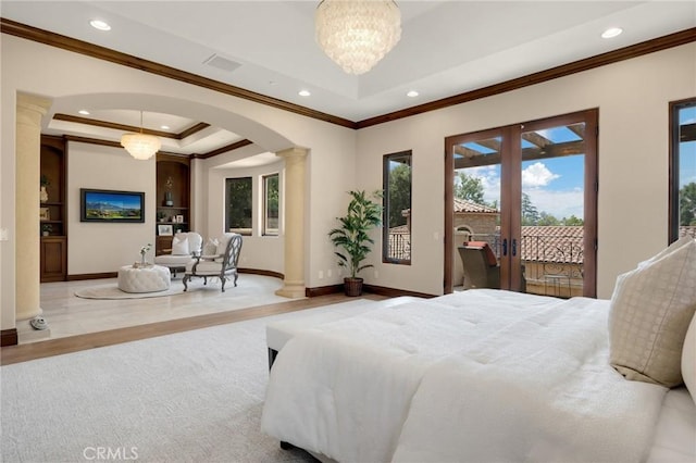 bedroom with an inviting chandelier, french doors, access to exterior, ornate columns, and light hardwood / wood-style floors