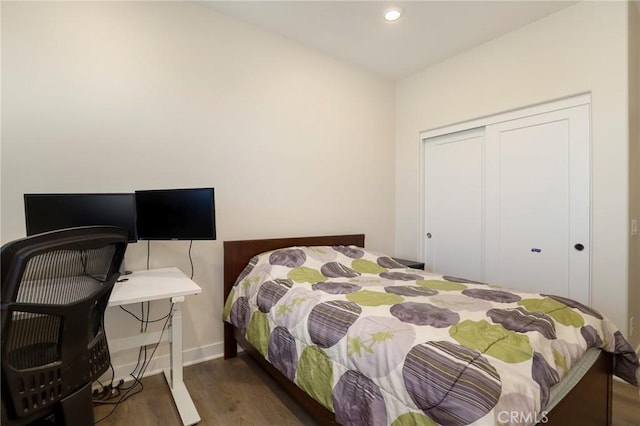 bedroom featuring a closet, baseboards, dark wood-type flooring, and recessed lighting