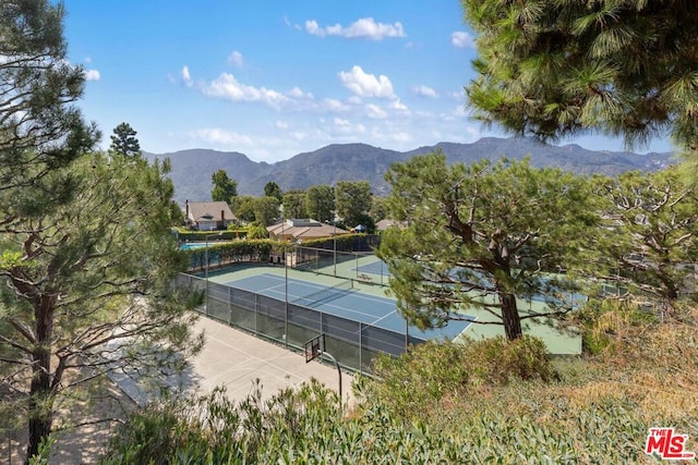 view of tennis court featuring a mountain view