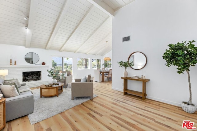 living room featuring wood-type flooring, vaulted ceiling with beams, a brick fireplace, and wooden ceiling