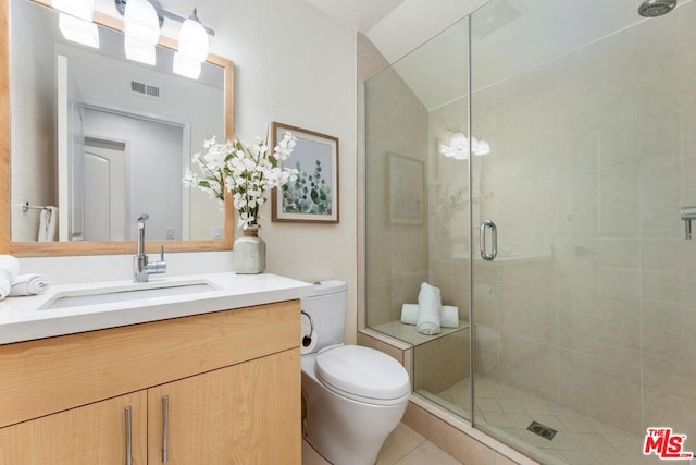 bathroom with tile patterned floors, vanity, toilet, and an enclosed shower