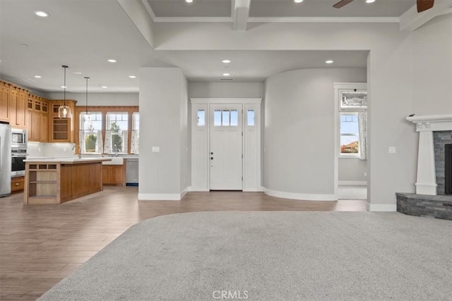 entrance foyer with light hardwood / wood-style flooring, ceiling fan, ornamental molding, and sink