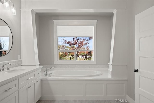 bathroom featuring a washtub and vanity