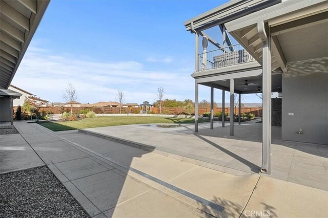 view of patio / terrace with ceiling fan and a balcony