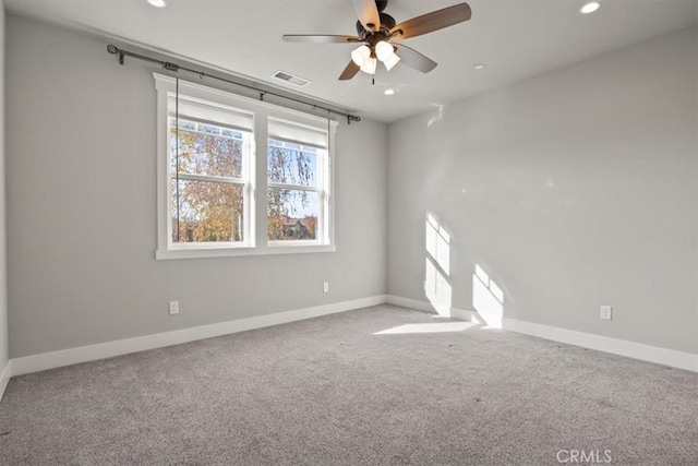 empty room featuring ceiling fan and carpet