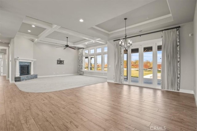 unfurnished living room with a high end fireplace, coffered ceiling, ceiling fan with notable chandelier, light hardwood / wood-style flooring, and beamed ceiling