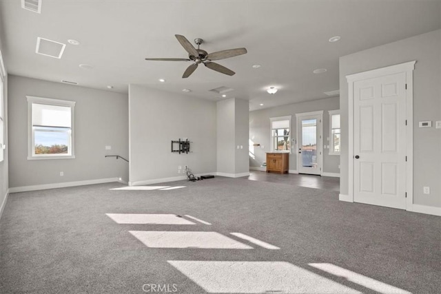 unfurnished living room featuring dark colored carpet and ceiling fan