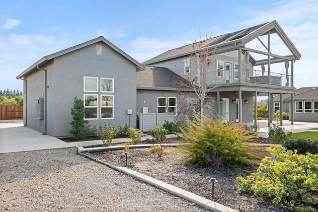 rear view of house with a patio area and a balcony