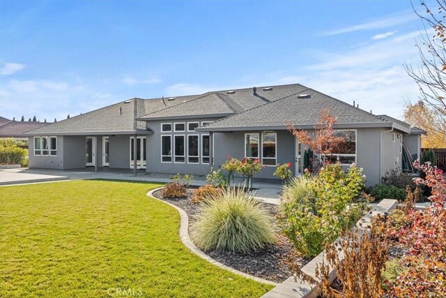 rear view of property with a yard and a patio