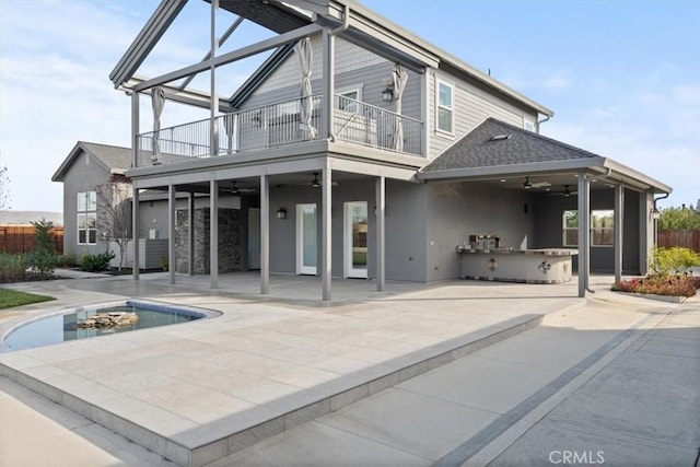 rear view of house featuring a patio area, ceiling fan, a balcony, and exterior kitchen