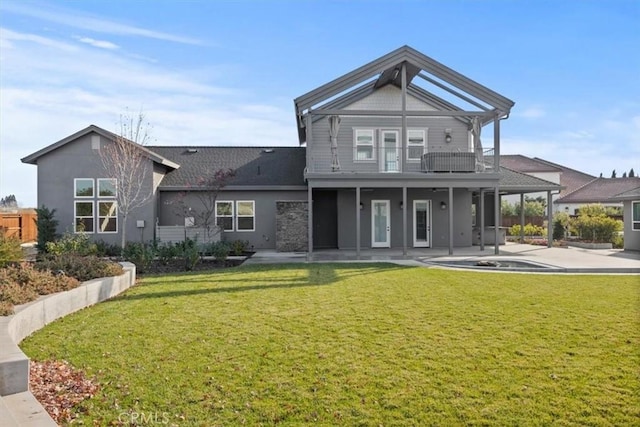 back of house featuring a lawn, a patio area, and a balcony