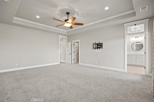 carpeted spare room featuring a tray ceiling, ceiling fan, and crown molding