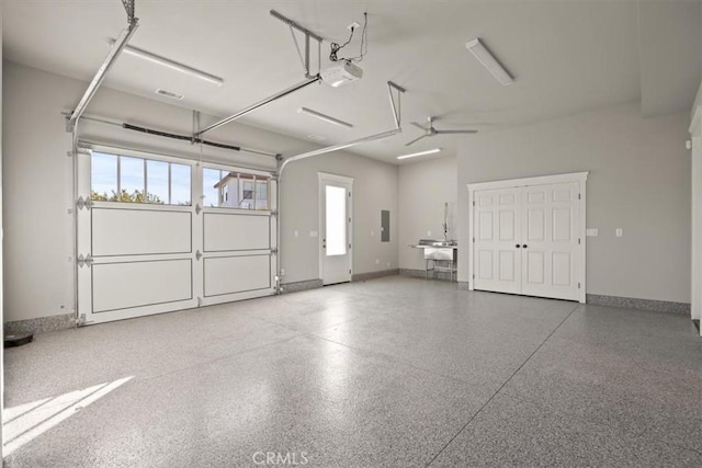 garage featuring ceiling fan, a garage door opener, and electric panel