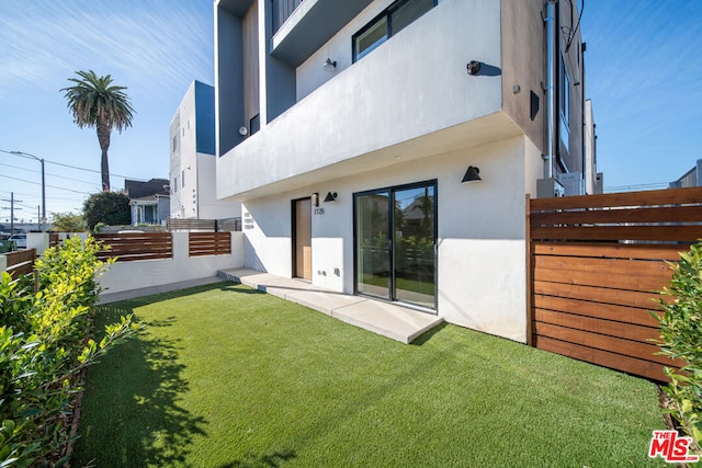 back of house featuring a lawn