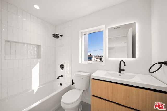 full bathroom featuring toilet, vanity, and tiled shower / bath