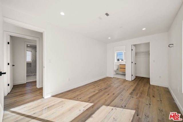 unfurnished bedroom with light hardwood / wood-style floors, a closet, and multiple windows