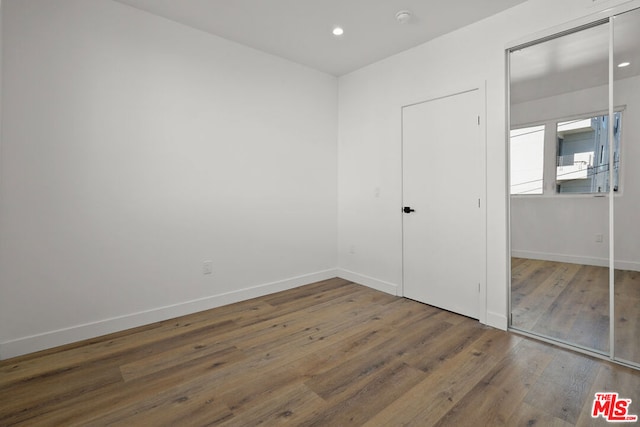 unfurnished bedroom featuring dark hardwood / wood-style floors and a closet