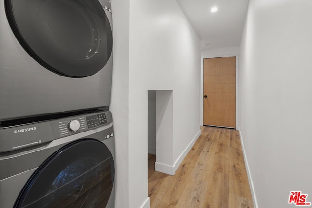 laundry area featuring stacked washer / dryer and light hardwood / wood-style floors