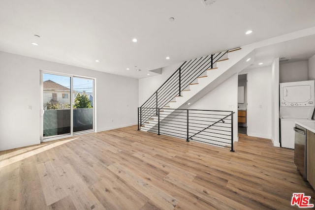 spare room featuring light hardwood / wood-style floors and stacked washer / dryer