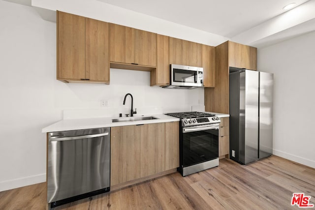 kitchen featuring sink, light wood-type flooring, and appliances with stainless steel finishes