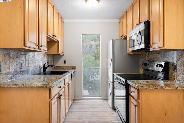 kitchen with crown molding, sink, appliances with stainless steel finishes, light hardwood / wood-style floors, and light stone counters