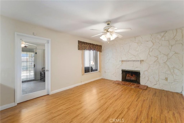 unfurnished living room with ceiling fan, a fireplace, and light hardwood / wood-style floors