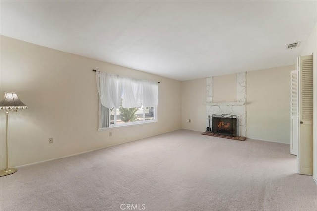 unfurnished living room with a fireplace and light colored carpet