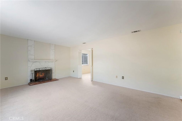 unfurnished living room with light carpet and a premium fireplace