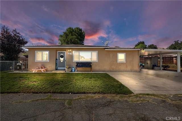 view of front of property featuring a lawn and a carport