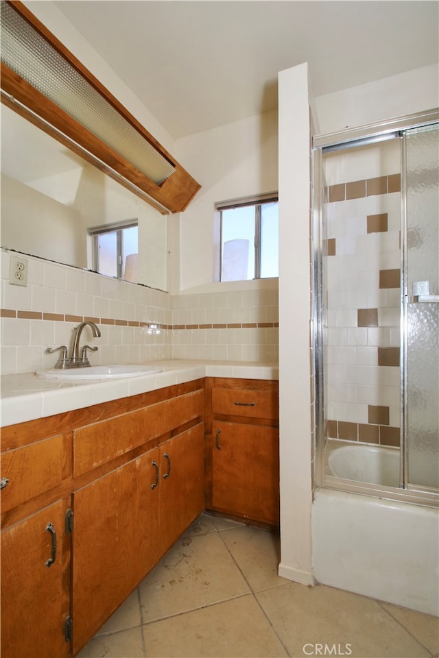 bathroom featuring vanity, backsplash, tile patterned floors, and combined bath / shower with glass door