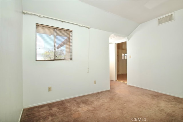 carpeted empty room with lofted ceiling