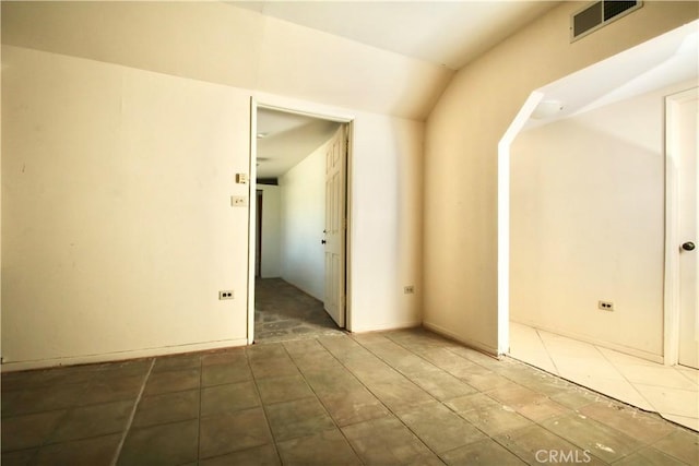 unfurnished room with lofted ceiling and visible vents