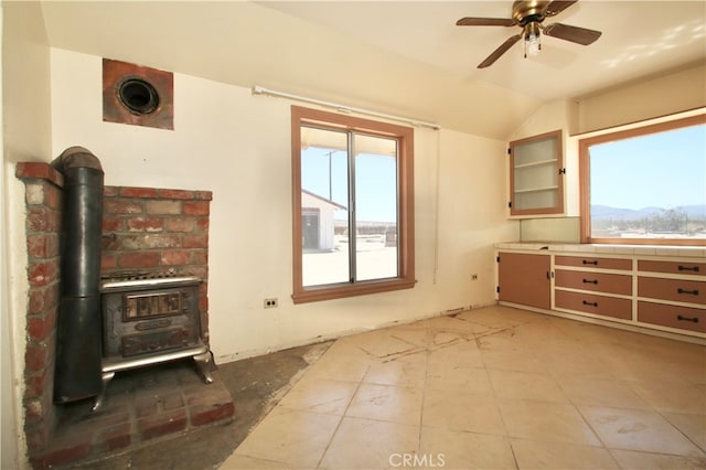 interior space featuring a mountain view, a wood stove, lofted ceiling, and plenty of natural light