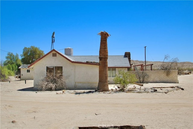 exterior space with stucco siding and a chimney