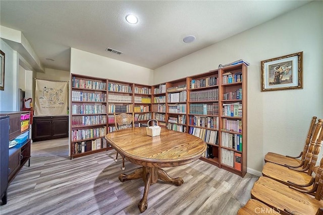 living area with light hardwood / wood-style floors and a textured ceiling