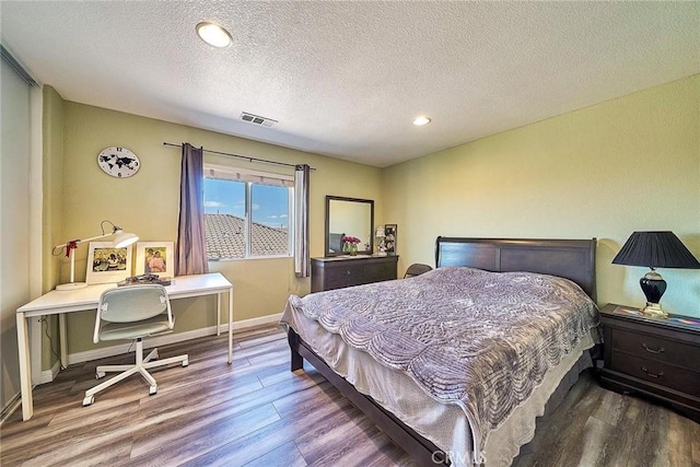 bedroom with wood-type flooring and a textured ceiling