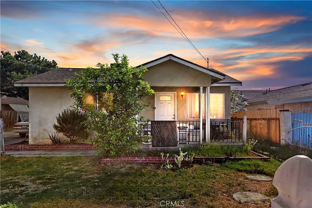 bungalow-style house featuring covered porch and a yard